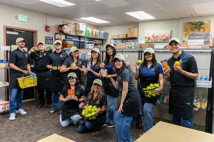 Butte College Basic Needs Support Team posing with pantry food items inside the Roadrunner Hub