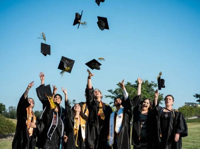 Butte College Graduates throw their graduation caps in the air