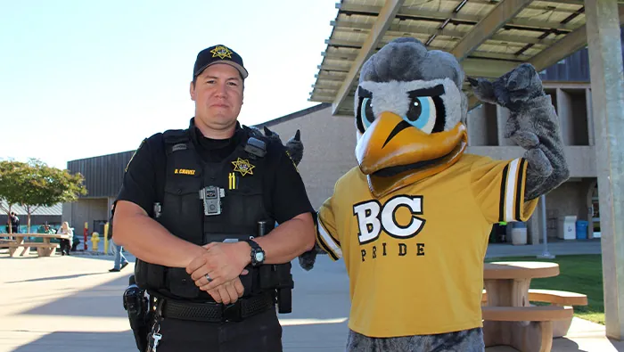 Campus Safety Officer poses with Dash Mascot