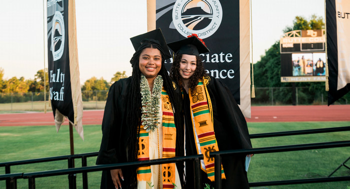 Two Butte College graduates smile at commencement.