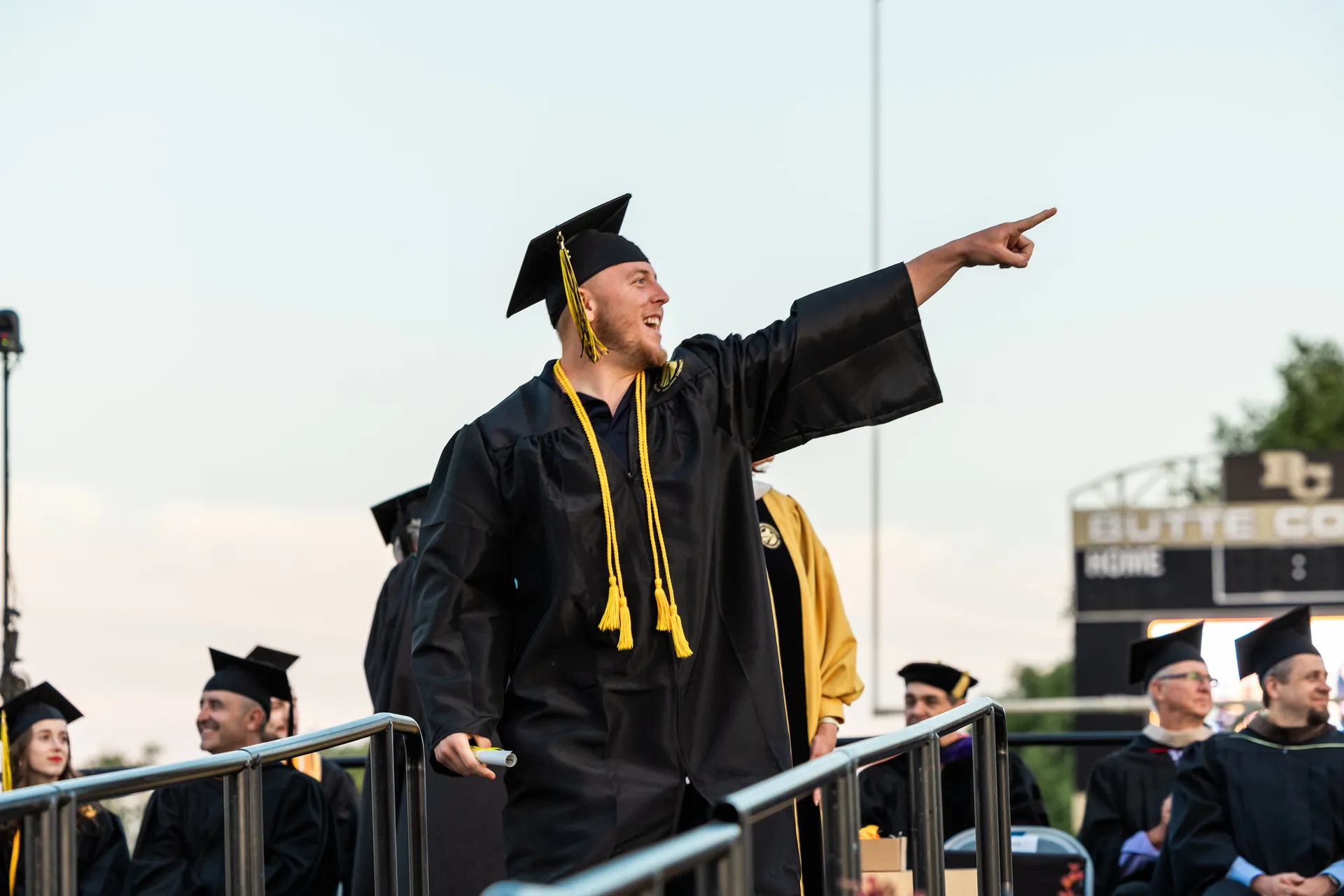 Butte College Graduate points to crowd at commencement ceremony