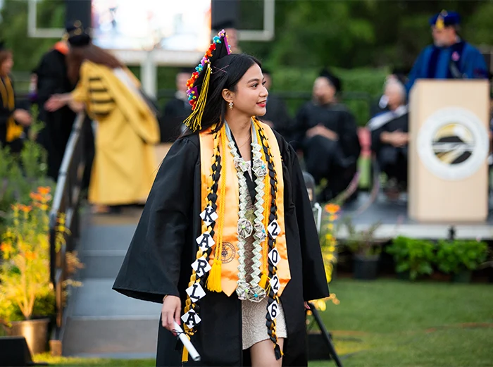 A 2026 Butte College graduate walks of the stage at commencement.