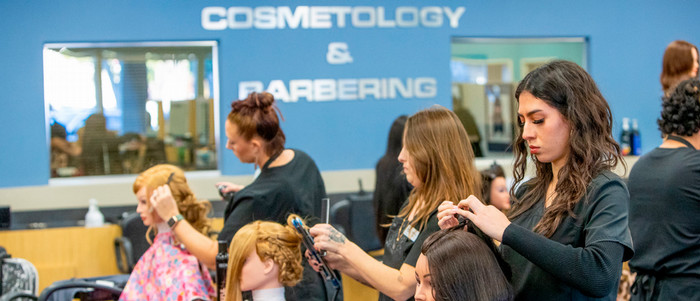 Students at the cosmetology center work on instructional mannequis