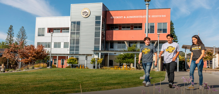 Three students walk on campus.