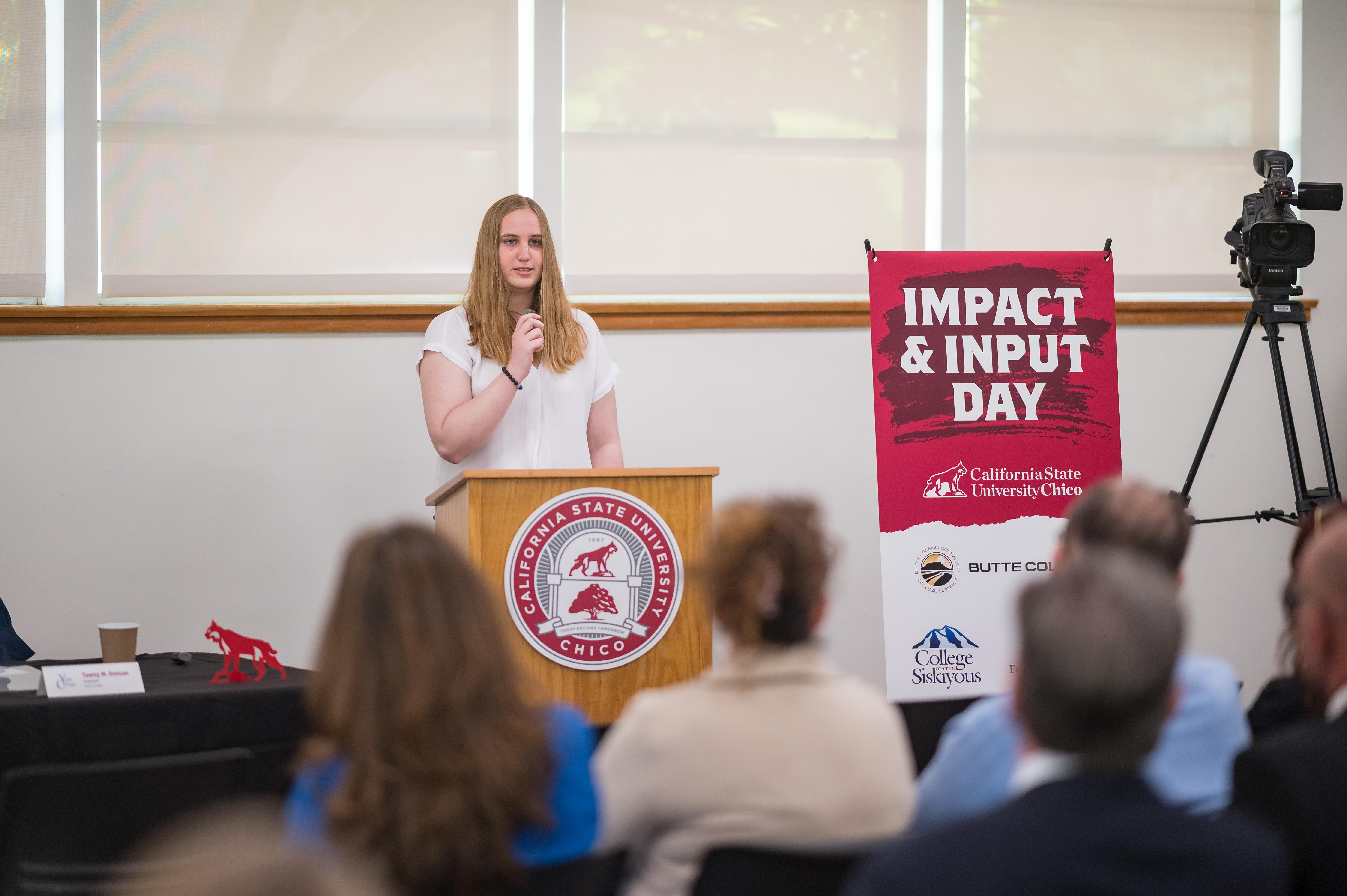 A Butte College transfer student is show speaking at a podium.