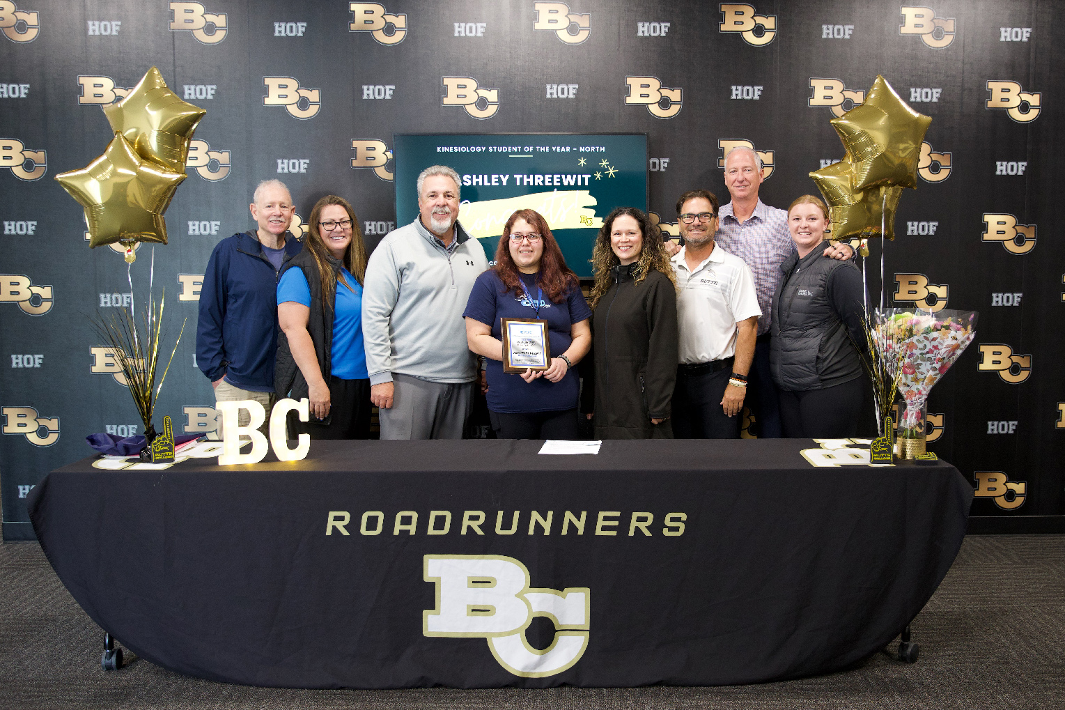 Ashley poses with her instructors and mentors while holding her award.